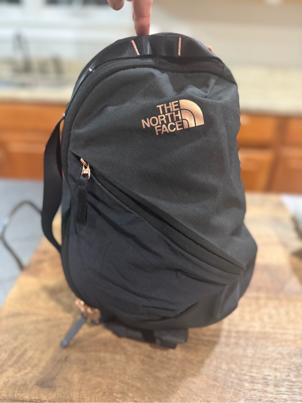 North Face Women's Isabella Sling Bag in black with rose gold hardware branding